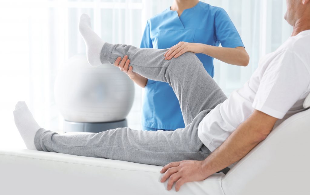 Fisioterapeuta ayudando a paciente